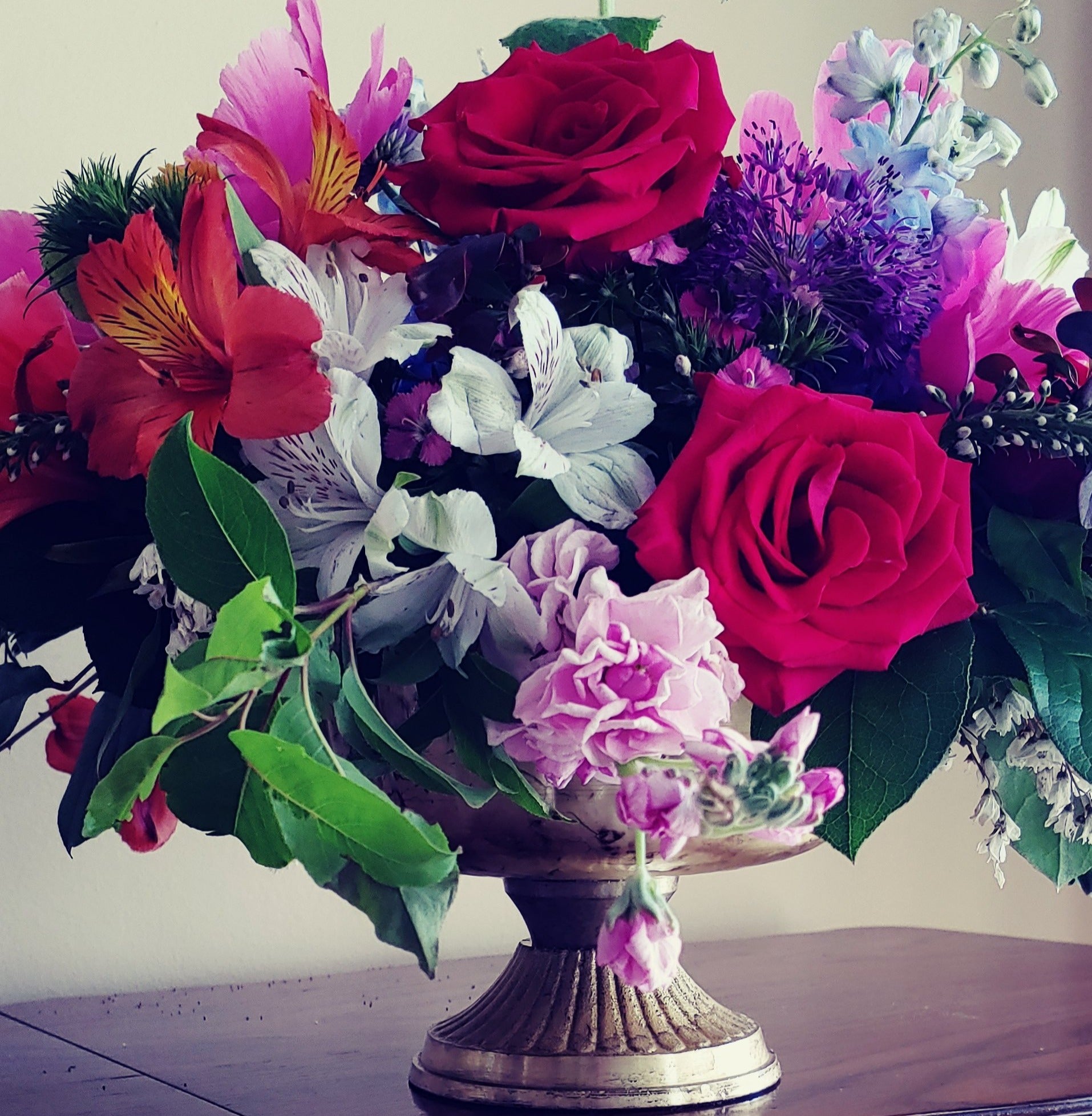a vase filled with lots of different colored flowers 