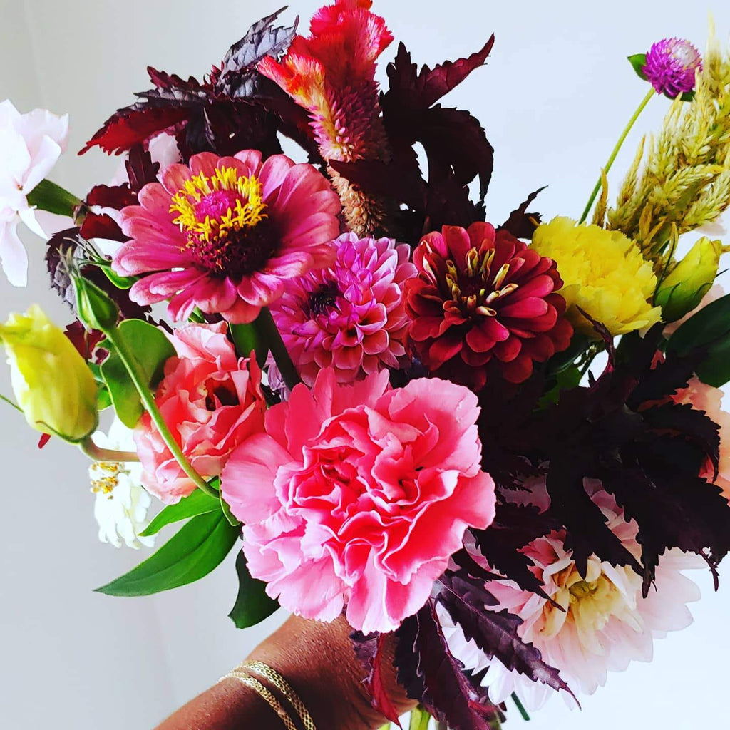 a vase filled with lots of different colored flowers 