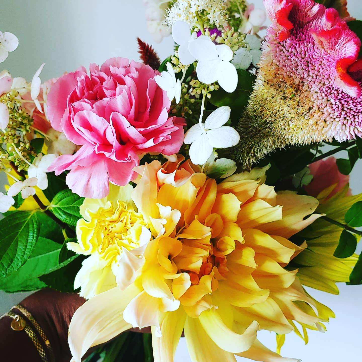 hand held flowers with lots of different colored flowers 